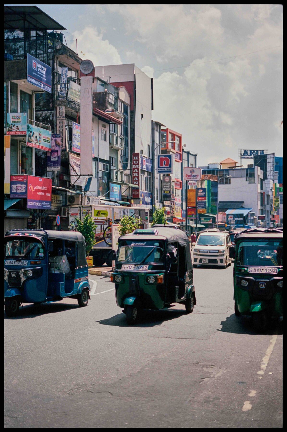 Colombo – Straße mit Tuk-Tuks und bunten Häusern