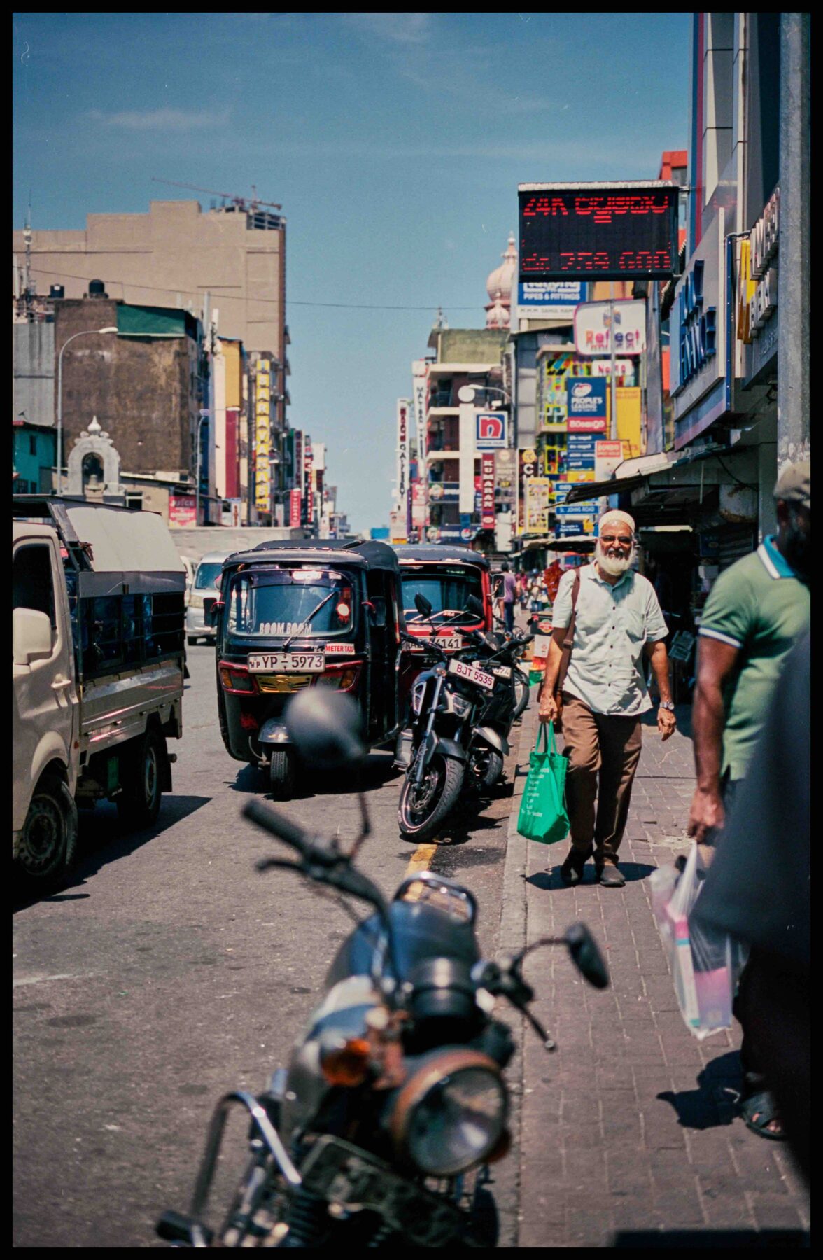 Colombo – Straße mit Passanten und Motorrad