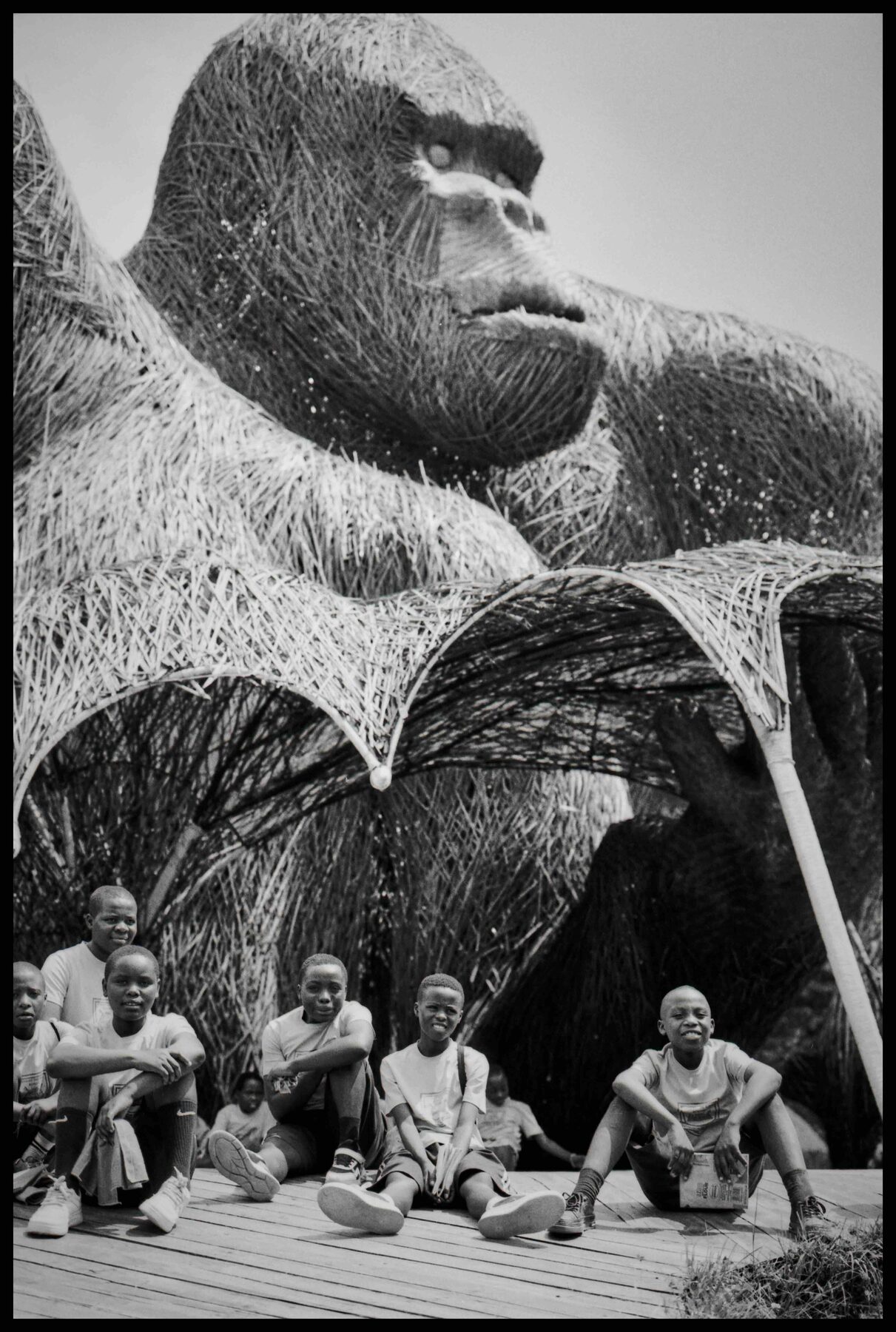 Ruanda – Gorilla-Skulptur aus Flechtwerk, davor sitzende Jungen
